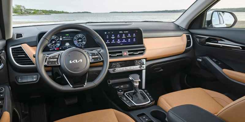 Kia car interior with a touchscreen, leather seats, and scenic backdrop.